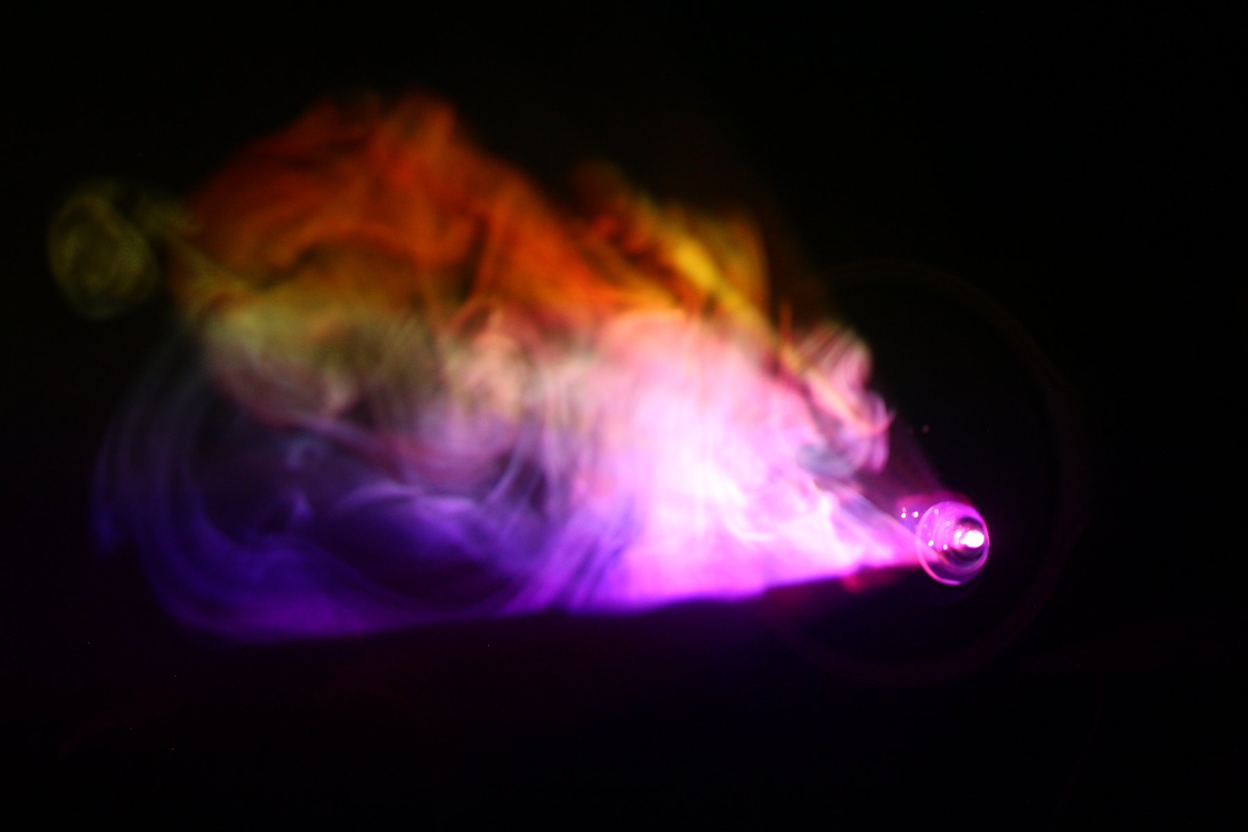 Bright pink and orange smoke cloud lit by the projector